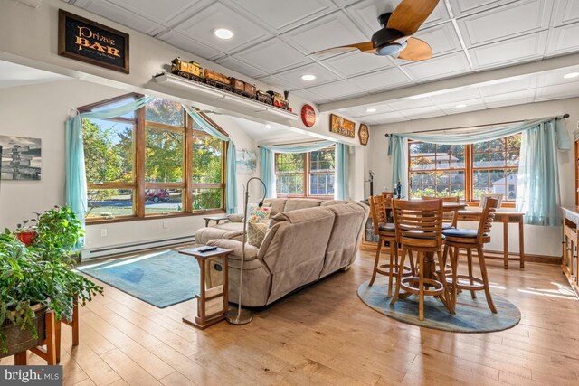 living room featuring ceiling fan, a baseboard radiator, and light wood-type flooring