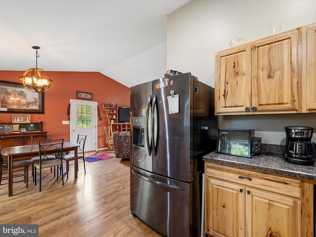 kitchen featuring vaulted ceiling, stainless steel fridge with ice dispenser, a notable chandelier, pendant lighting, and light hardwood / wood-style floors