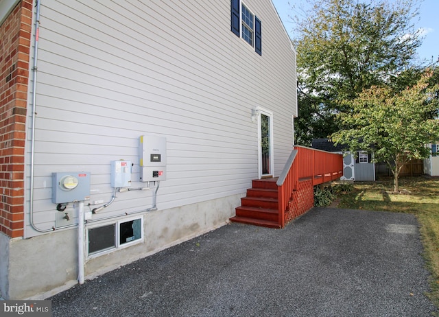 view of side of property with a patio area and a storage unit