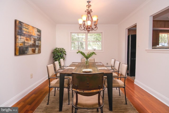 dining space featuring crown molding, hardwood / wood-style floors, and a wealth of natural light