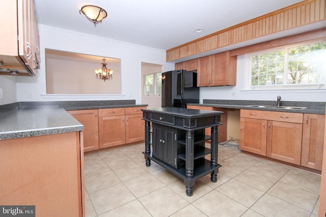 kitchen featuring light tile patterned floors, sink, an inviting chandelier, and black fridge