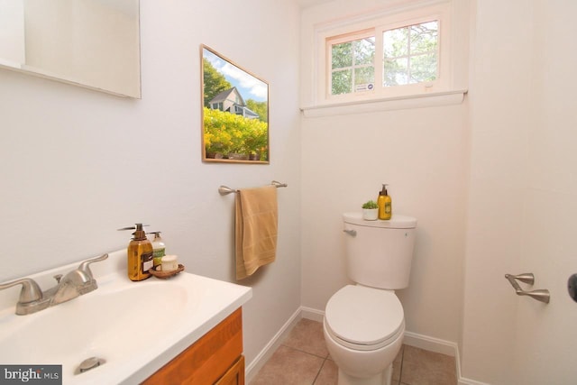 bathroom with toilet, vanity, and tile patterned floors