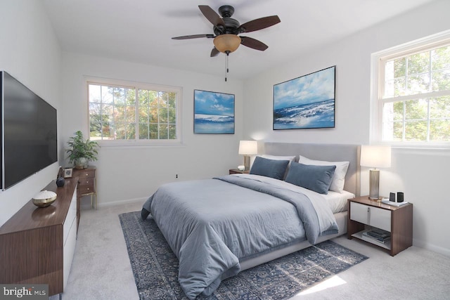 carpeted bedroom featuring multiple windows and ceiling fan