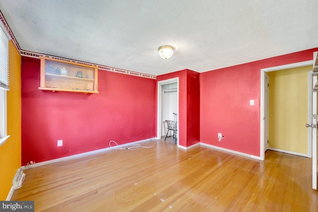 unfurnished bedroom with a textured ceiling and hardwood / wood-style floors