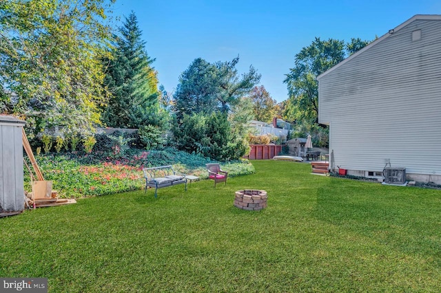 view of yard featuring central AC and a fire pit