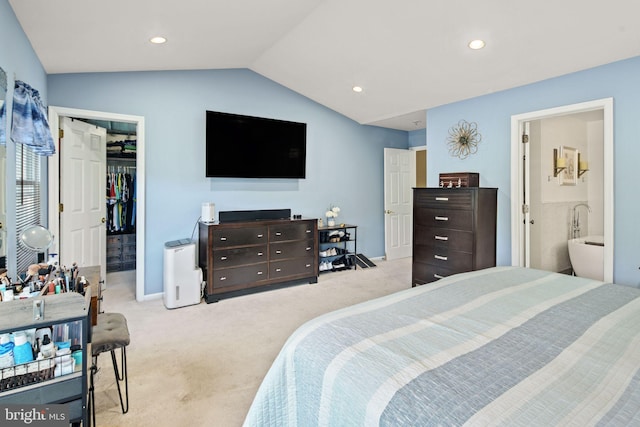 carpeted bedroom with a closet, connected bathroom, and vaulted ceiling