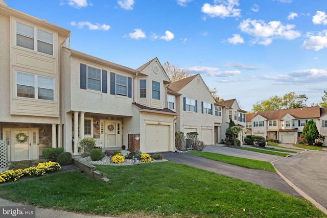 view of property with a garage and a front lawn