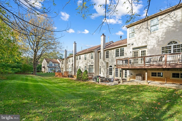 back of house featuring a wooden deck and a lawn