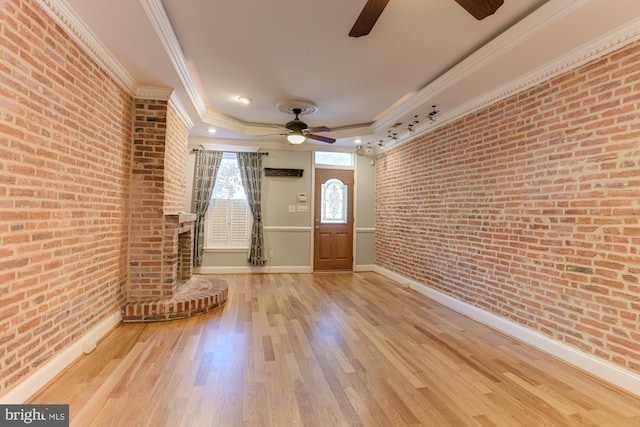 entryway featuring ornamental molding, ceiling fan, hardwood / wood-style flooring, and brick wall