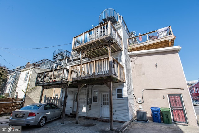 back of property with a wooden deck and cooling unit