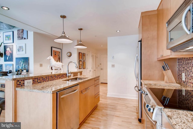 kitchen with light hardwood / wood-style flooring, hanging light fixtures, sink, light brown cabinetry, and appliances with stainless steel finishes