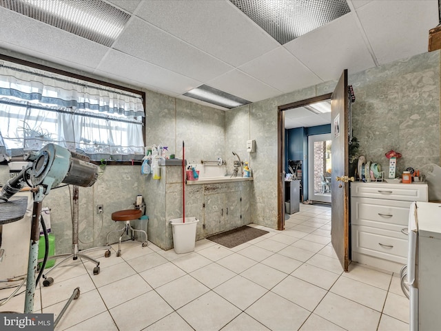 bathroom with a paneled ceiling, tile patterned floors, and toilet