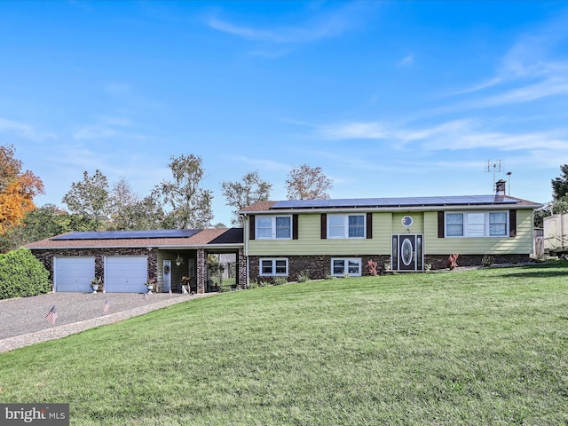 view of front of house featuring solar panels, a front yard, and a garage