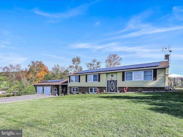 view of front of home featuring solar panels, a front lawn, and a garage