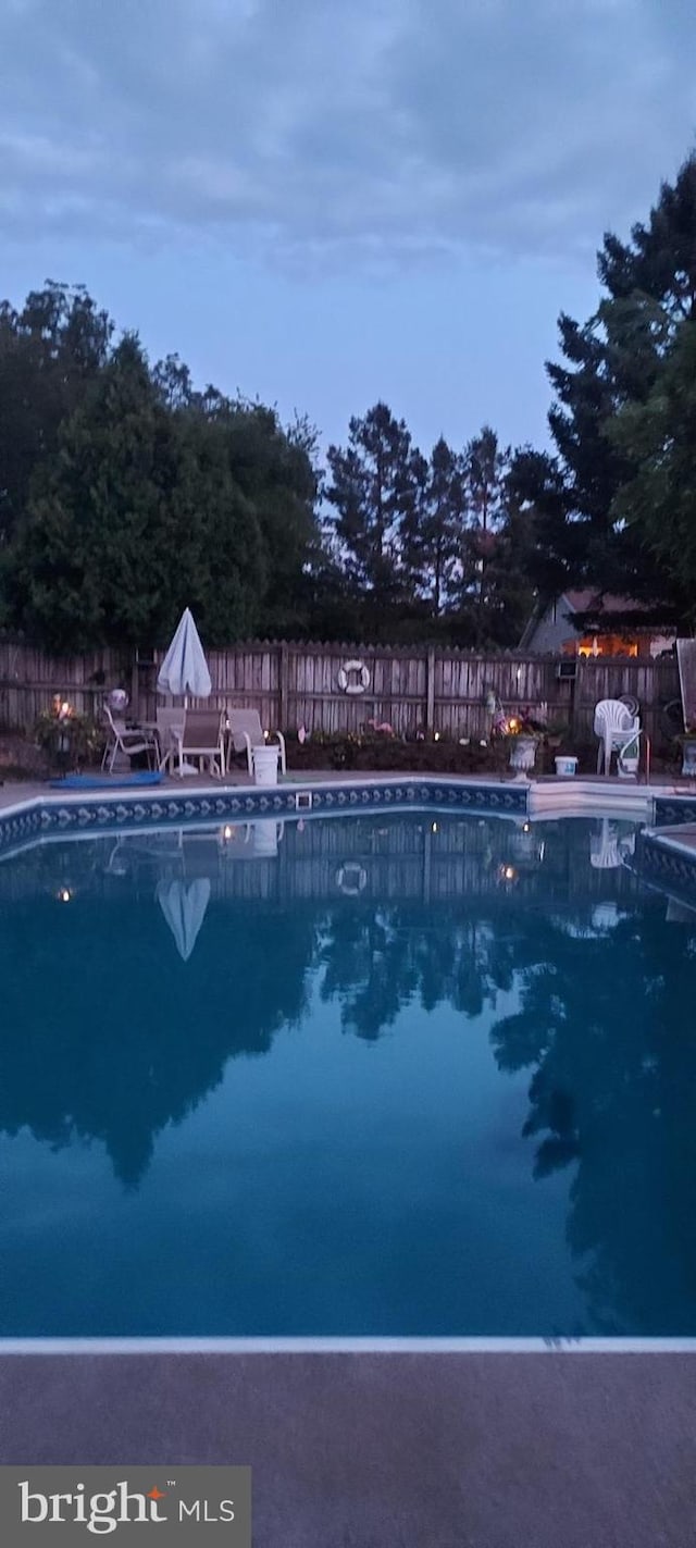 view of pool at dusk