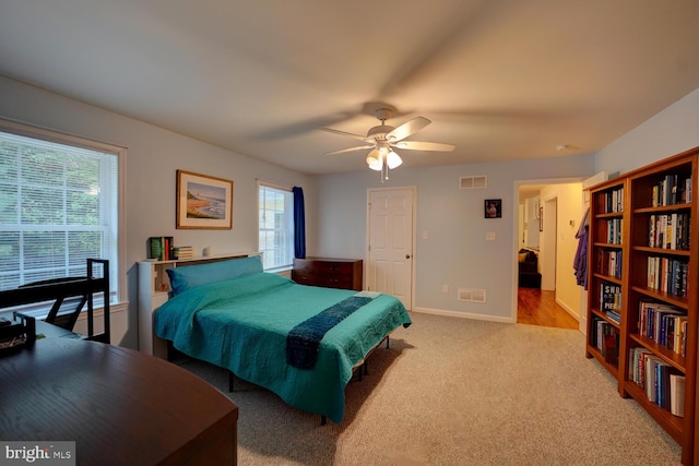 bedroom featuring light colored carpet and ceiling fan