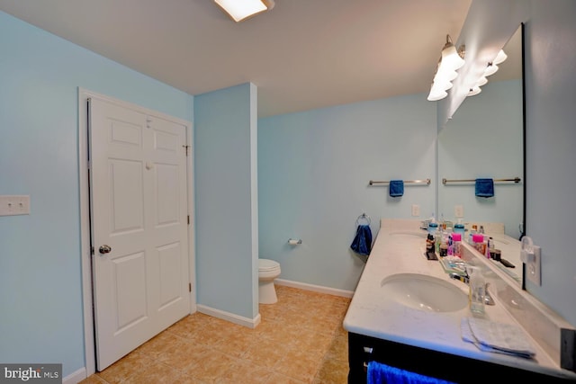 bathroom with tile patterned flooring, vanity, and toilet