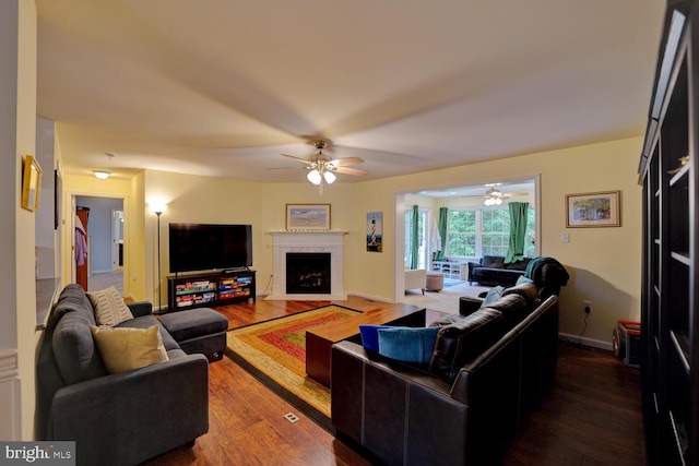 living room with ceiling fan and dark hardwood / wood-style flooring