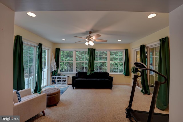 exercise room featuring plenty of natural light, ceiling fan, and light carpet