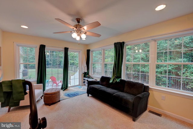 living room featuring light carpet and ceiling fan