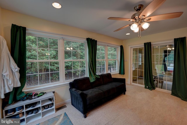 interior space featuring ceiling fan and light colored carpet