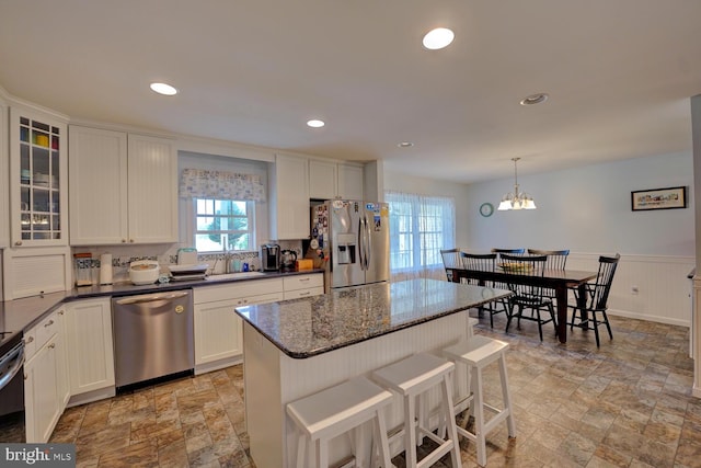 kitchen featuring a center island, hanging light fixtures, white cabinetry, and stainless steel appliances