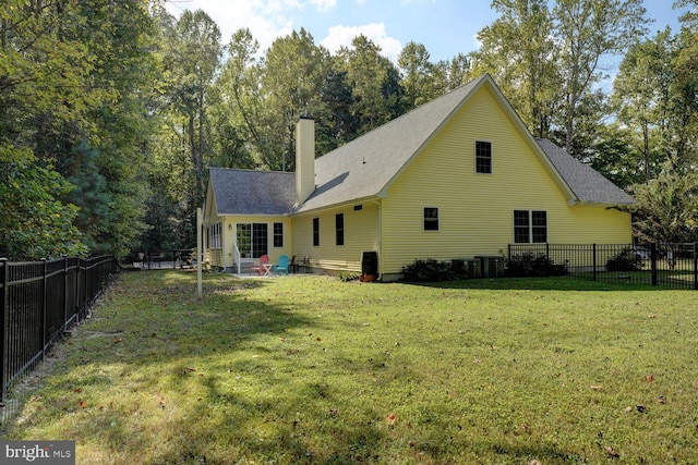 rear view of property with a patio and a lawn