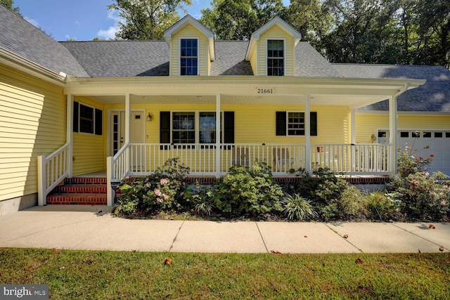 cape cod-style house with a garage and a porch