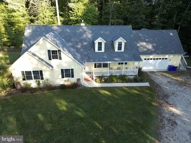 view of front of home featuring a front lawn, a porch, and a garage