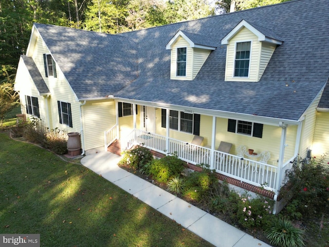 cape cod home with a front lawn and covered porch