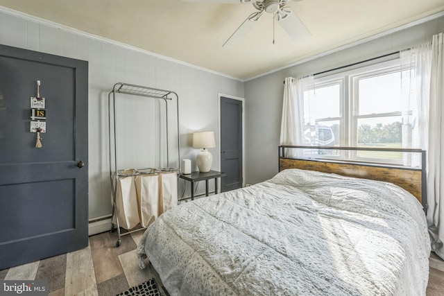 bedroom with ceiling fan, crown molding, a baseboard radiator, and hardwood / wood-style floors