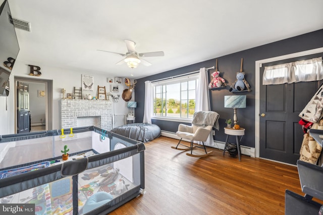 living room with ceiling fan, wood-type flooring, and a fireplace