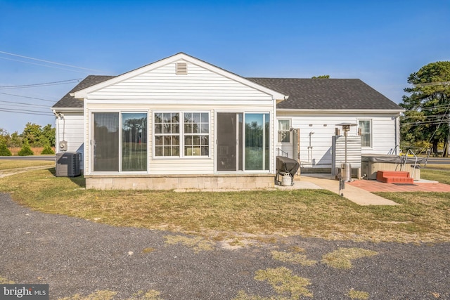 rear view of house with a yard, cooling unit, and a patio