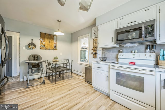 kitchen featuring white electric range oven, white cabinets, and pendant lighting