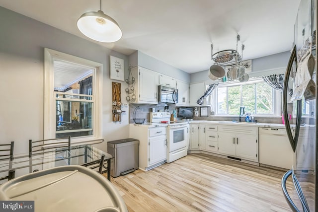 kitchen featuring sink, a chandelier, white cabinets, white appliances, and tasteful backsplash