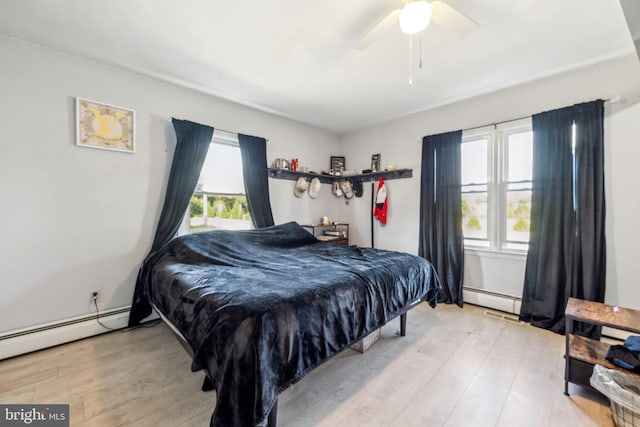 bedroom with light hardwood / wood-style flooring, a baseboard heating unit, and ceiling fan