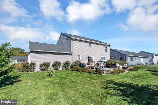 rear view of property featuring a lawn