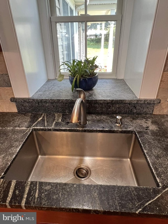 room details featuring sink and dark stone counters