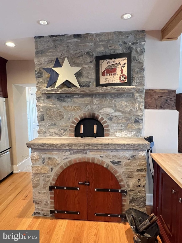 interior details with hardwood / wood-style floors and stainless steel refrigerator