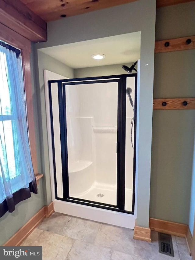 bathroom with a shower with door and a healthy amount of sunlight