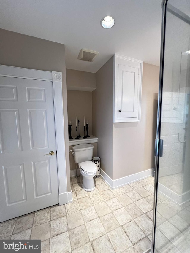 bathroom with a shower with shower door and toilet