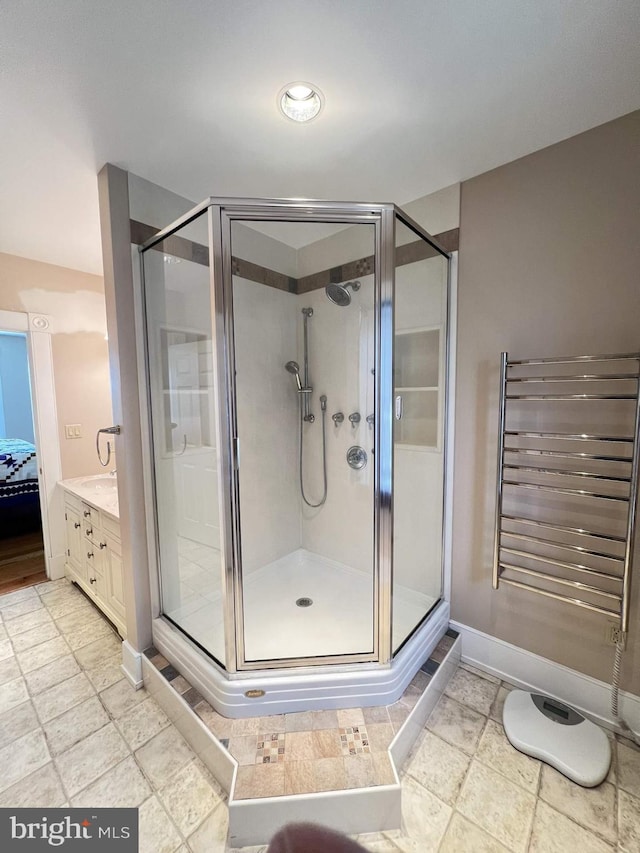 bathroom featuring radiator, vanity, and a shower with shower door