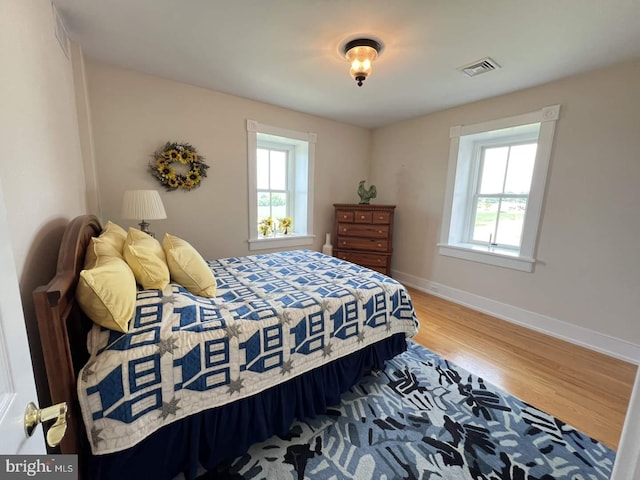 bedroom featuring wood-type flooring and multiple windows