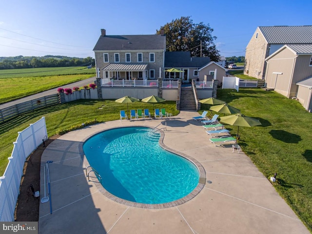 view of pool featuring a patio and a lawn