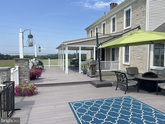 wooden terrace featuring a grill