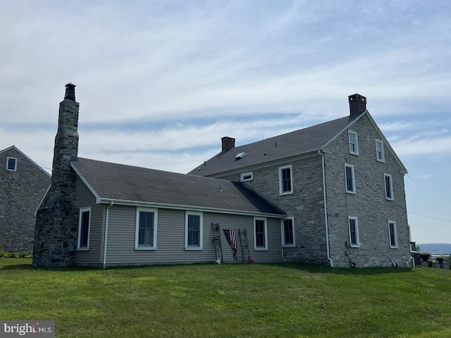 rear view of house featuring a lawn