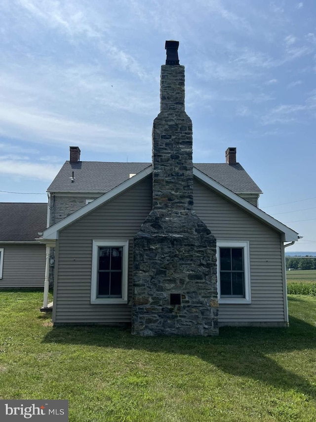 rear view of house featuring a lawn