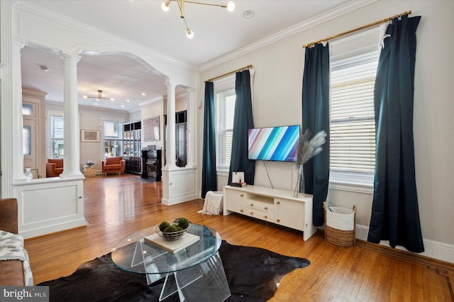 living room featuring ornate columns, light hardwood / wood-style floors, and crown molding