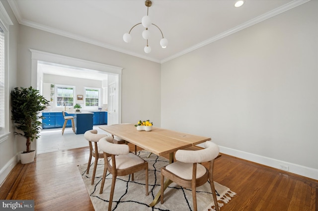 dining room featuring ornamental molding, a chandelier, and light hardwood / wood-style flooring