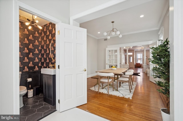 interior space with dark wood-type flooring, crown molding, a notable chandelier, and sink